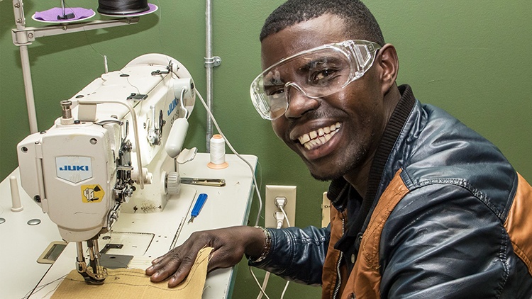 Man learning to sew.